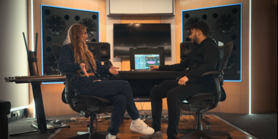 A woman and a man in a recording studio discussing music.