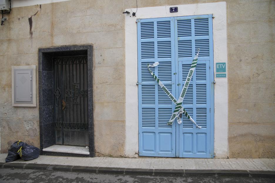 Blue double doors cordoned off with police tape.