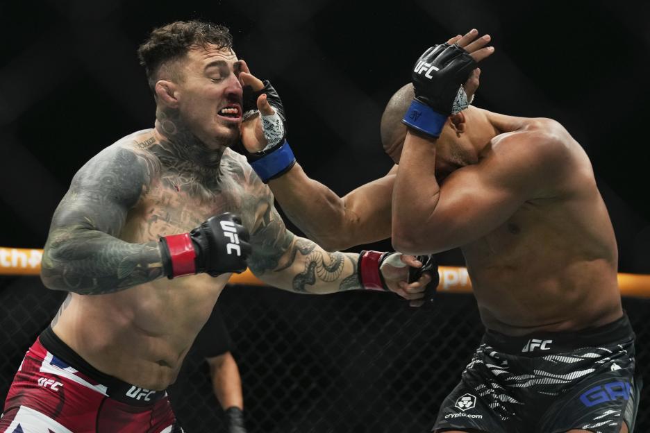 England's Tom Aspinall fights Ciryl Gane of France during a heavyweight title bout.