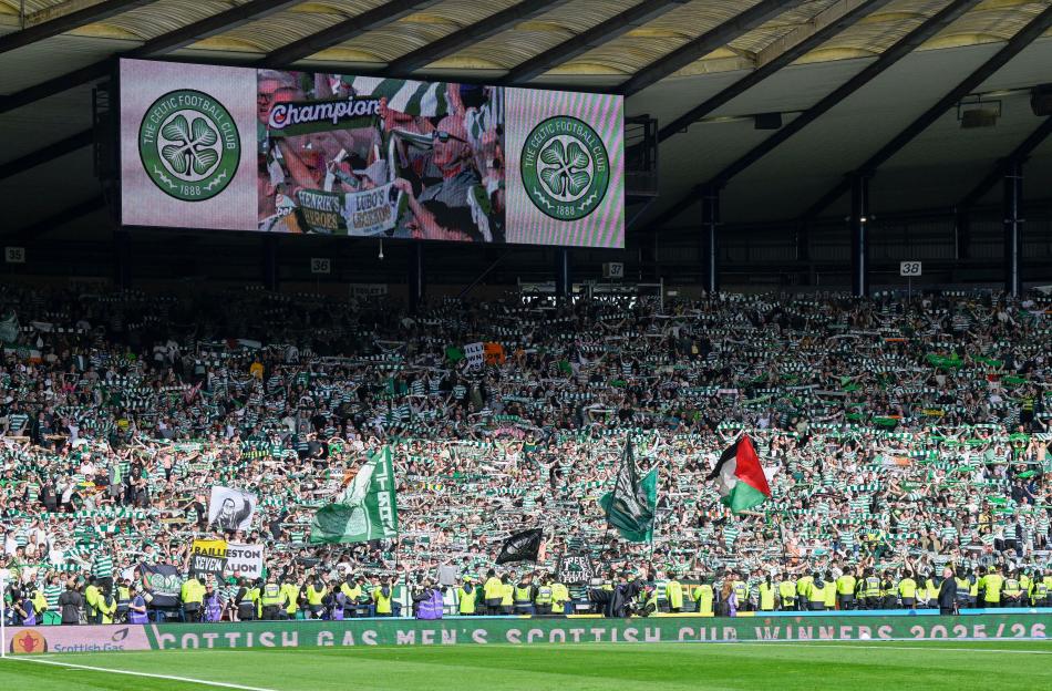 Fans at Hampden Park celebrate Celtic's League & Cup double with flags, scarves, and banners, as the club's crest is shown on a large screen above.