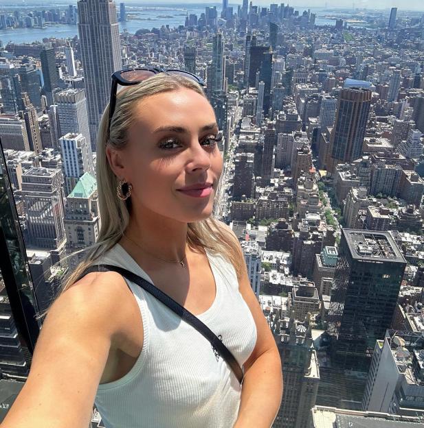 Sky Sports presenter Emma-Louise Paton smiling in front of the New York City skyline including the Empire State Building.