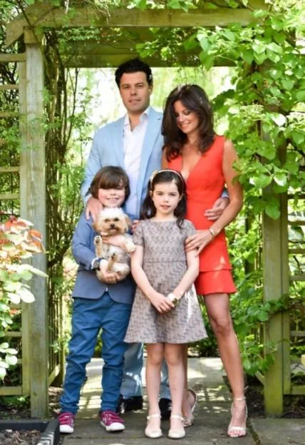 Deborah James with her husband, children and dog, posing in a garden.