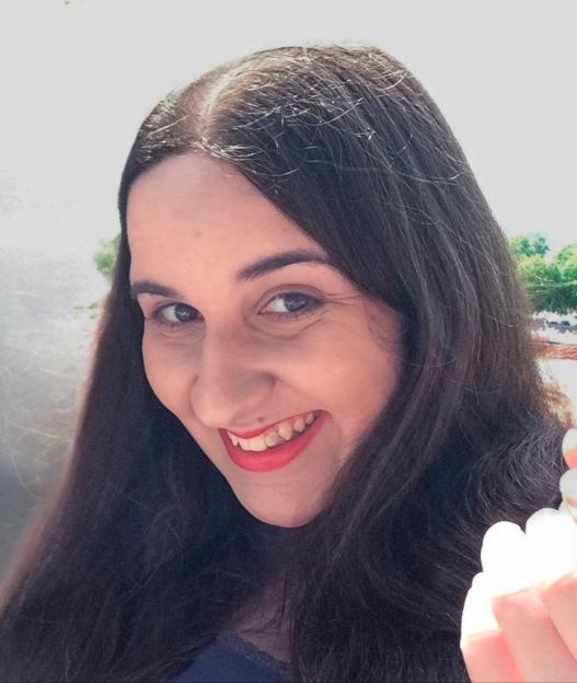 Close-up of Megan Bhari smiling, with long dark hair.