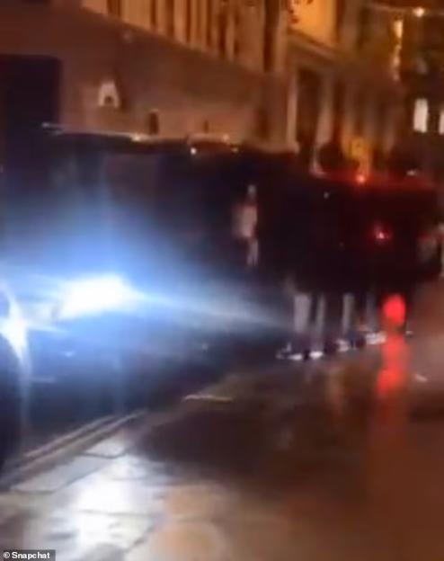 A blurry, dark image of a street at night with bright car headlights.