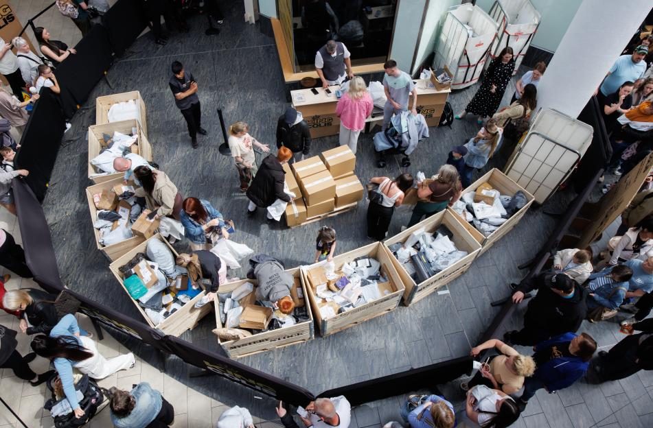 Overhead view of people sorting through items in large wooden crates.
