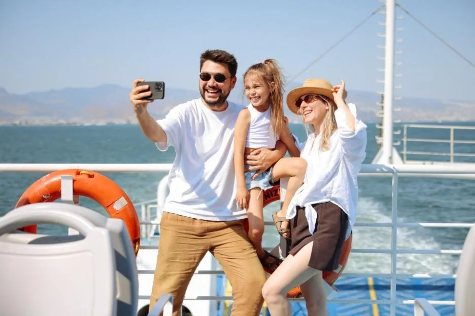 A family taking a selfie on a ferry boat.