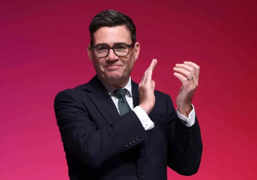 Prime Minister Andy Burnham clapping on stage at the Labour Party annual conference.