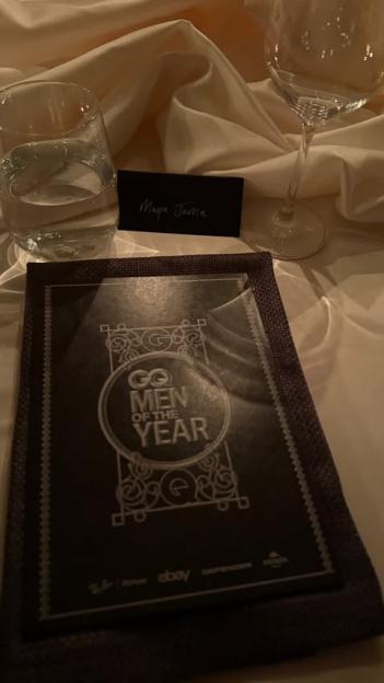 A place card for Maya Jama and a GQ Men of the Year program on a table.