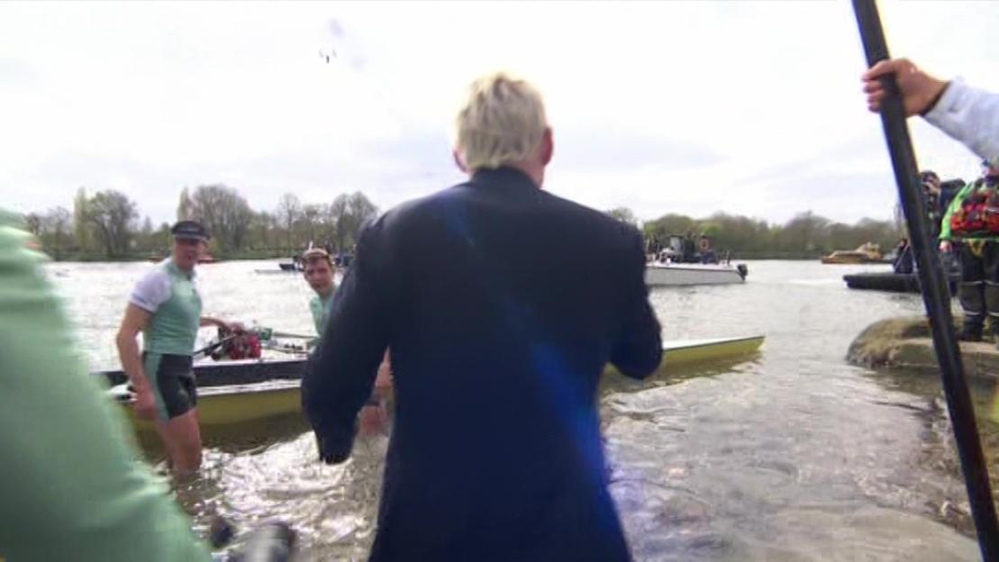 Jamie Laing wading into the water during a boat race.