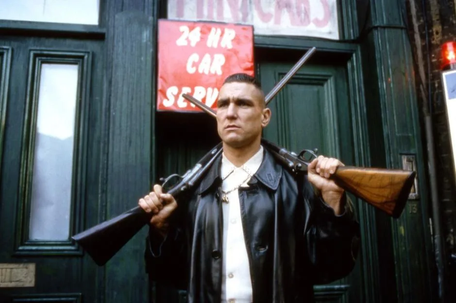Vinnie Jones as Big Chris with two shotguns in Lock, Stock and Two Smoking Barrels.