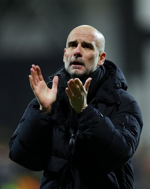 Manchester City manager Pep Guardiola applauding.