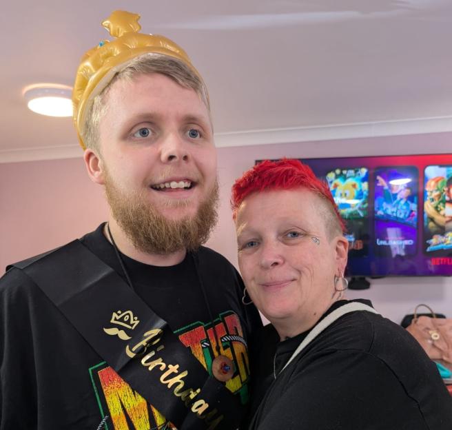 Samantha Fairbairn embracing her son Andre, who is wearing an inflatable crown and a "Birthday" sash.