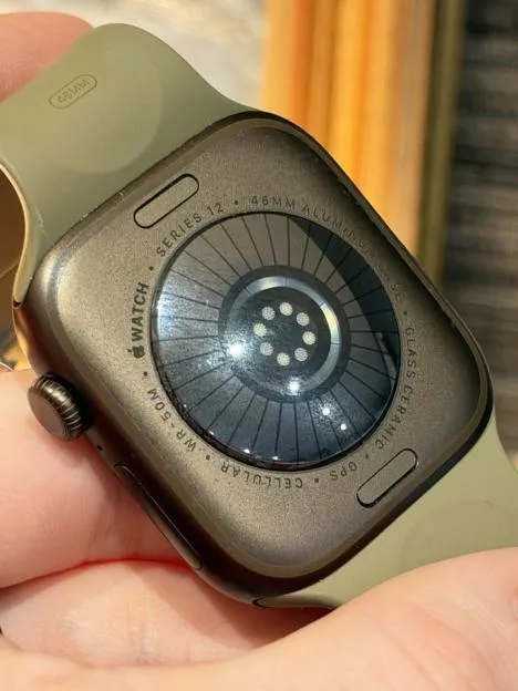 Close-up of the back of an Apple Watch Series 10, showing the sensor array and inscribed text indicating specifications such as 46mm aluminum case, GPS, and cellular.
