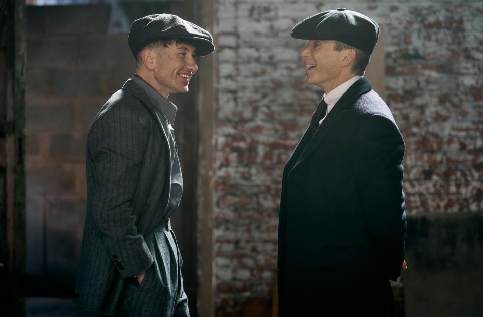 Film still from Peaky Blinders: The Immortal Man, featuring Barry Keoghan as Duke Shelby and Cillian Murphy as Tommy Shelby, both smiling and wearing period clothing.