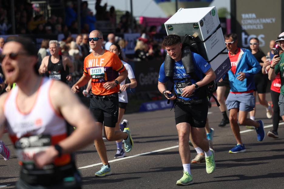 A runner carries a fridge on his back during the 2026 London Marathon.