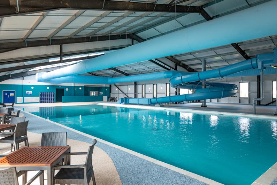 An indoor swimming pool with a long blue slide.