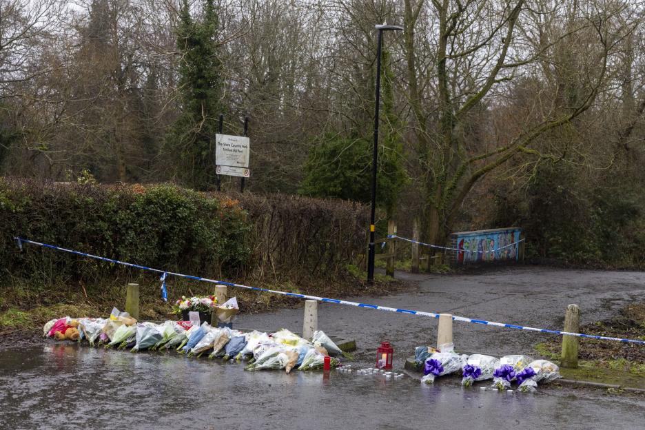 Tributes to murdered schoolboy Leo Ross at Shire Country Park, Birmingham, with flowers, candles, and a teddy bear placed behind police tape.