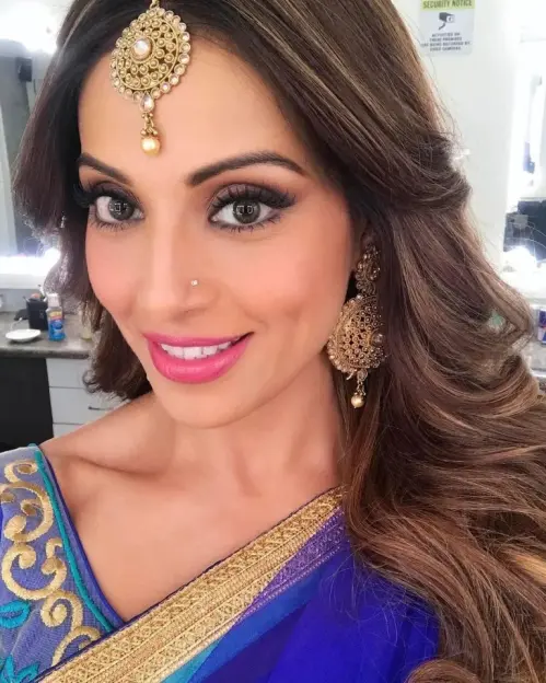Woman with elaborate Indian jewelry and blue sari.