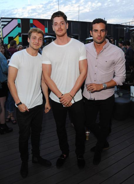 Three men standing outdoors on a wooden deck at The DISARONNO Terrace London.