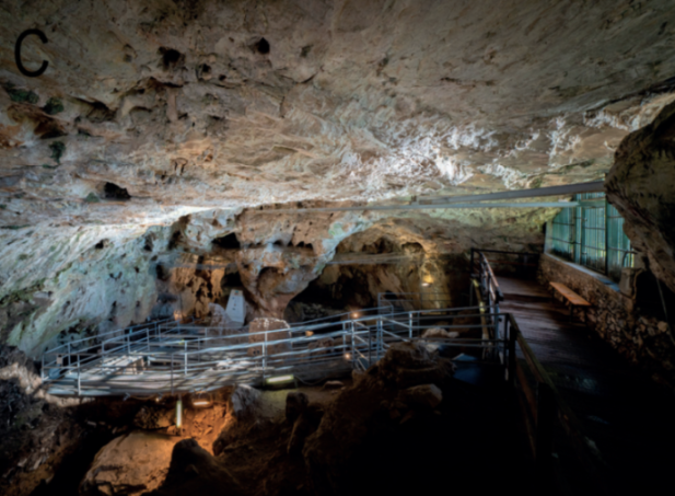 Illuminated walkways and platforms inside a large cave.