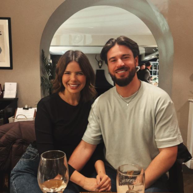 Olivia Frazer and her fiance Greg smiling at a restaurant.