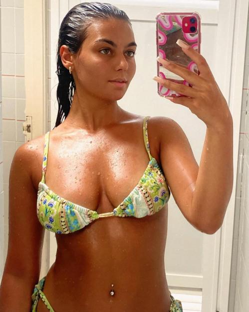 Megan Forte Clarke taking a mirror selfie wearing a green patterned bikini.