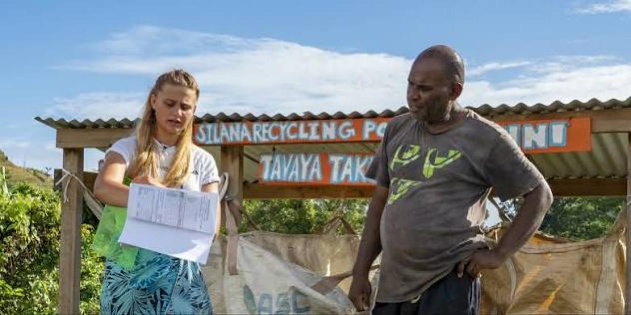 A woman and a man in front of a "Silana Recycling Point" sign.