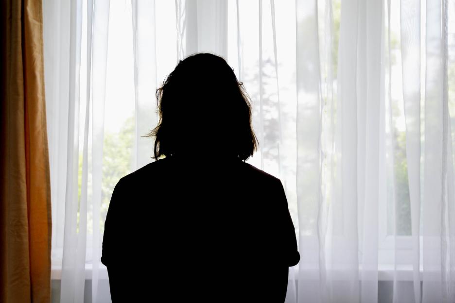 Silhouette of a woman in front of a window.