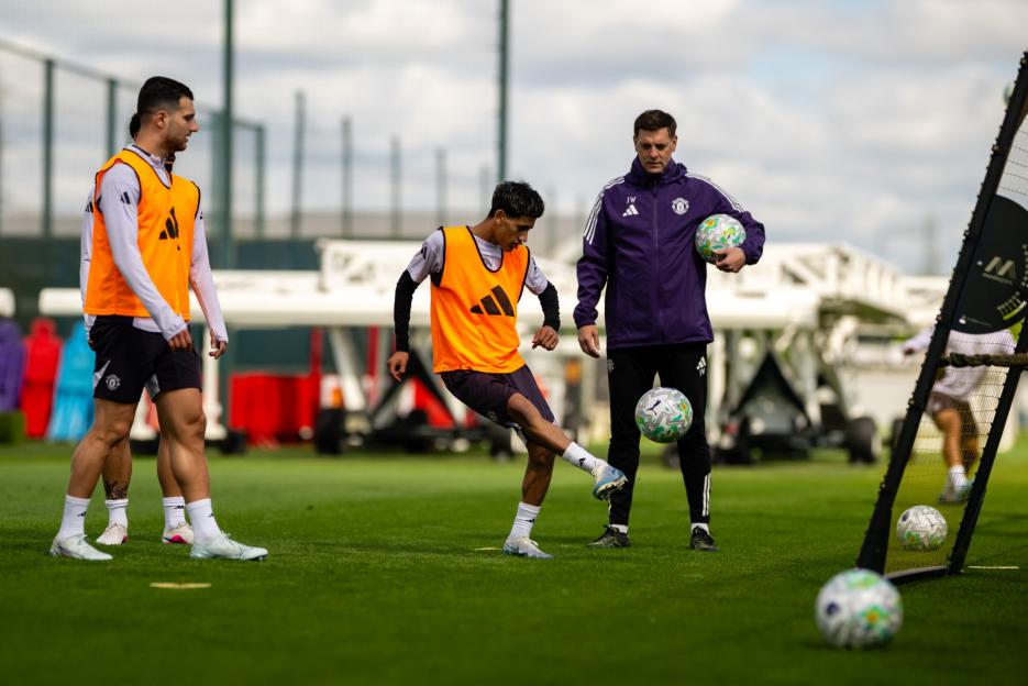 Three Manchester United players and a coach during a training session.