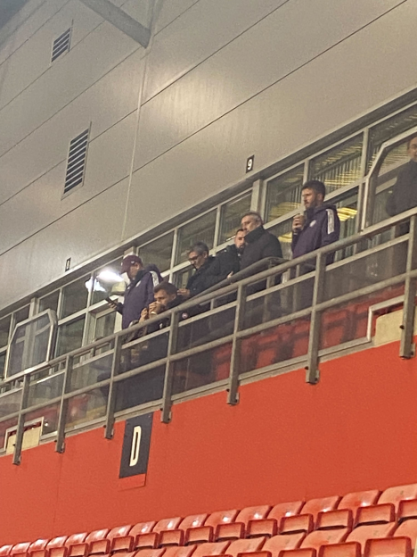 People watching from a stadium box.