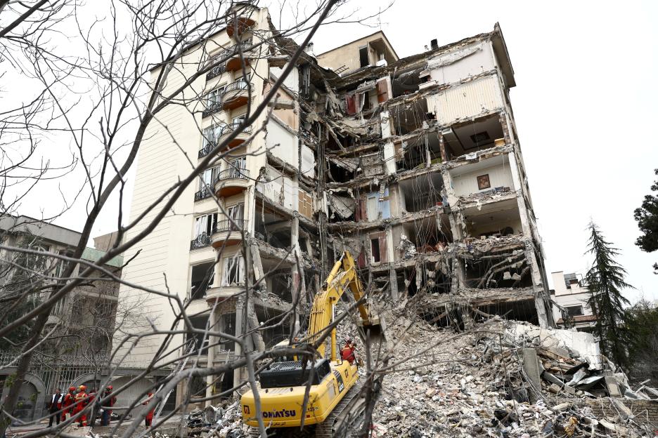 : Emergency personnel work at the site of a strike on a residential building, in Tehran