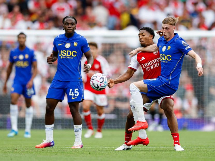 Football players from Arsenal and Chelsea competing for the ball.