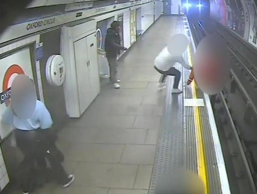a group of people are standing on a subway platform .
