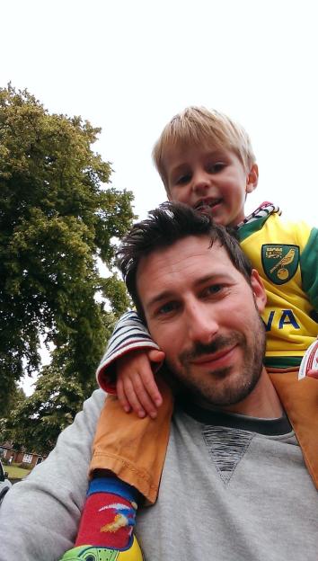 Tristan Cork and Finnbar Cork, a father and son, with Finnbar sitting on his father's shoulders.