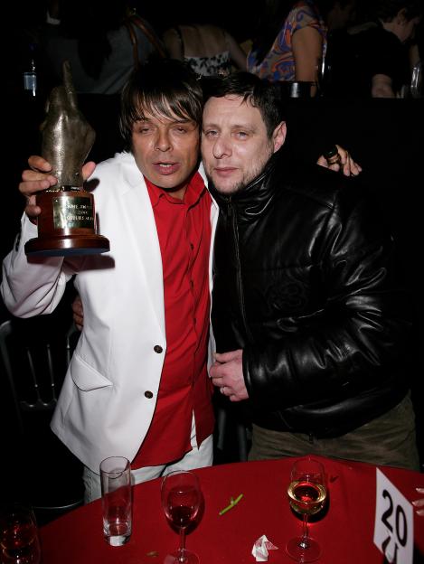 Mani and Shaun Ryder with an NME Awards trophy at a party.