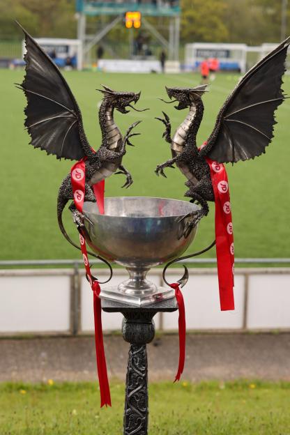 Football trophy adorned with two dragon figures and red ribbons.