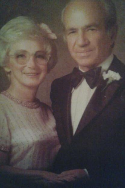 Photo of a man and woman dressed up, smiling.