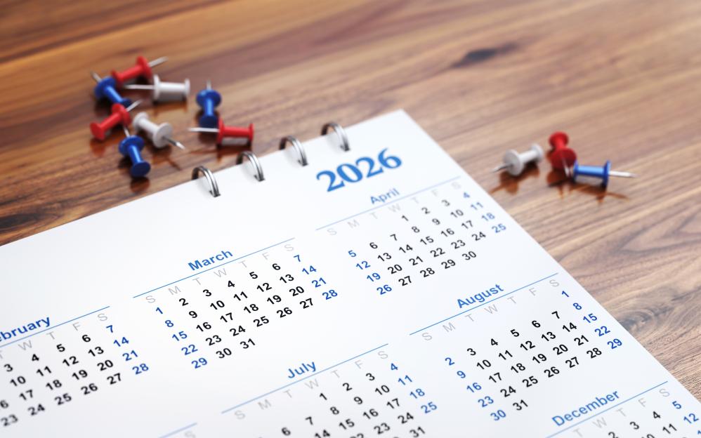 Illustration of a 2026 calendar on a wooden background with colorful pushpins.