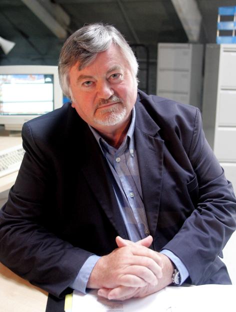 Roger Cook, the journalist and presenter, posing for a photograph.