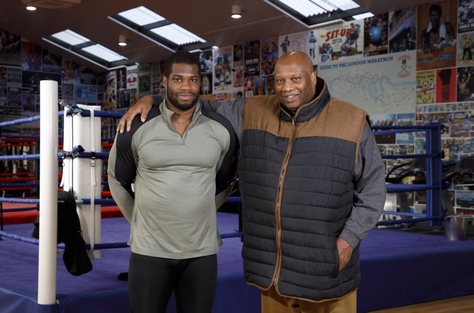 British heavyweight boxer Daniel Dubois and his father, Dave, pose for a portrait in a boxing gym.