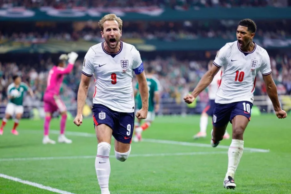 England soccer players Harry Kane and Jude Bellingham celebrating on the field.
