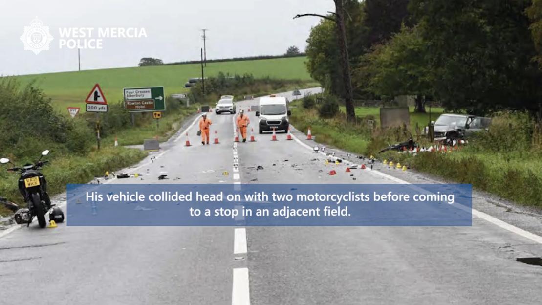 Road with police officers, a damaged motorcycle, and evidence markers after a collision.
