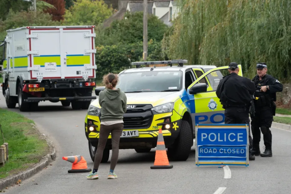 Police and a bomb disposal truck at a road closure.