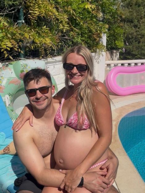 Rozz Darlington and her partner posing by a pool while she is pregnant.
