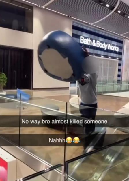 A man throws a large seat over a railing.