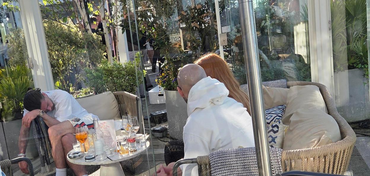 Jack Grealish is seen sleeping in a corner of a rooftop bar in Manchester.