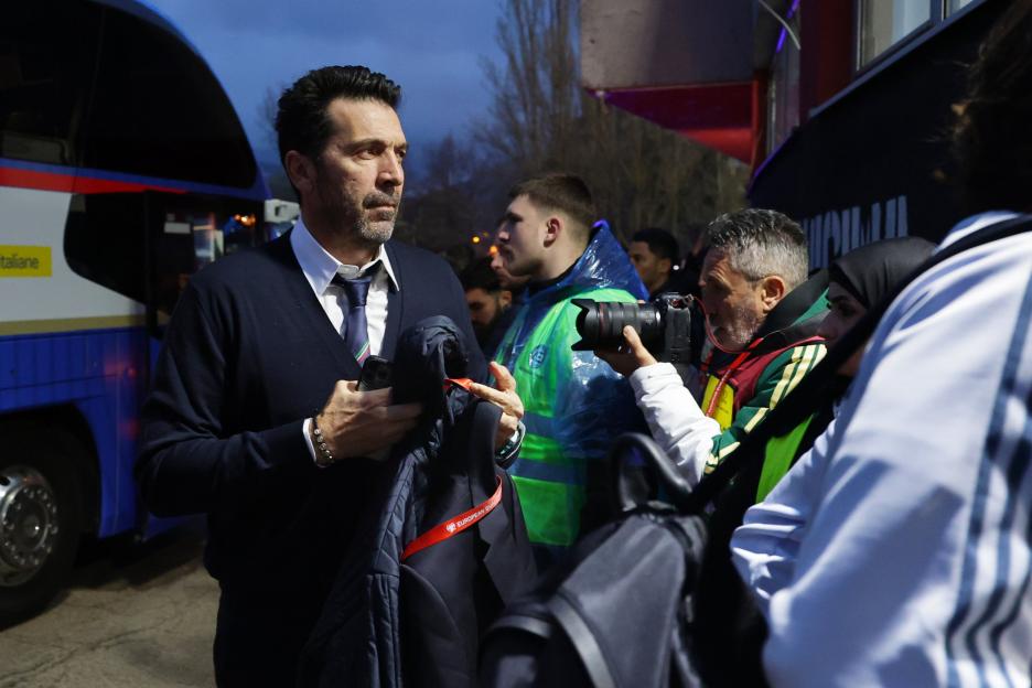 Gianluigi Buffon holding a jacket with a "European Qualifiers" lanyard.