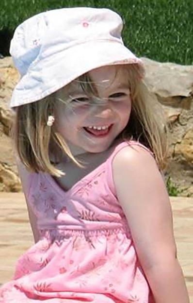 A smiling Madeleine McCann wearing a white hat and pink dress.