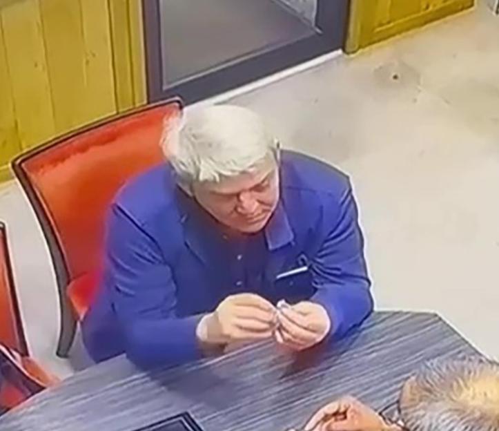 CCTV footage of a man in a blue jacket trying to swallow a ring.
