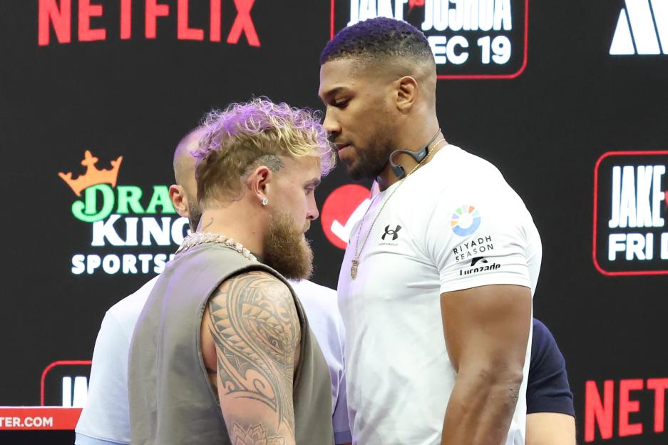 Boxers Jake Paul and Anthony Joshua face each other during a press conference.